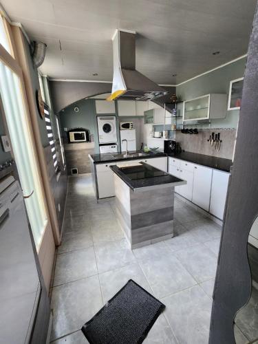 une grande cuisine avec des placards blancs et un grand îlot dans l'établissement Maison 8 personnes, à Vendin-le-Vieil