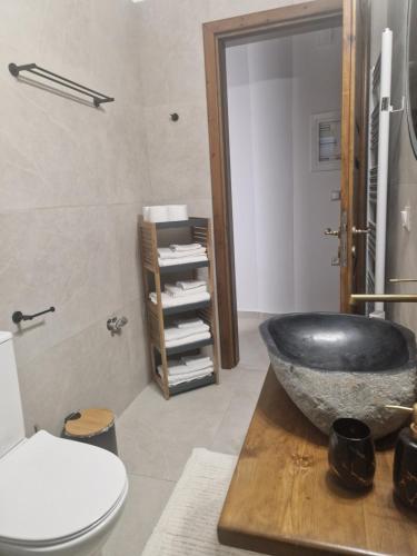 uma casa de banho com um grande lavatório preto num balcão em MELATO HOUSES em Valtessiniko