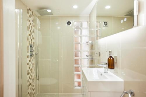 a white bathroom with a sink and a shower at The Bermondsey Place - Cozy 2BDR Flat in London