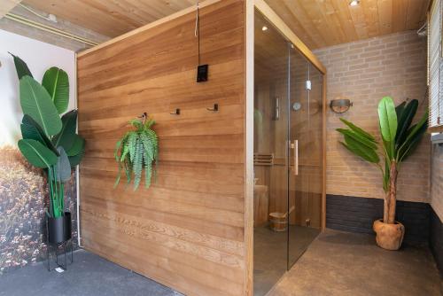 Wellness Landhuis Drenthe في Schoonloo: حمام مع دش مع جدار خشبي