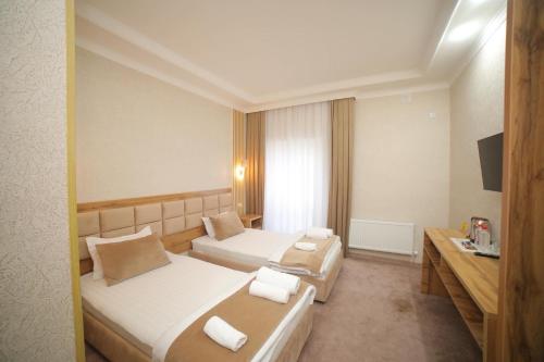 烏爾根奇的住宿－Hotel Tinchlik Plaza，酒店客房设有两张床和电视。