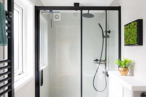una doccia con una porta in vetro in un bagno di Lodge Pimpelmees Nunspeet Veluwe a Nunspeet