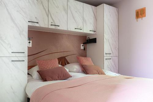 una camera da letto con un grande letto con lenzuola e cuscini rosa di Lodge Pimpelmees Nunspeet Veluwe a Nunspeet