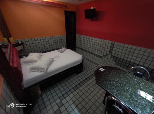 um pequeno quarto com uma cama e um balcão em Motel Estoril (Adult Only) em Recife