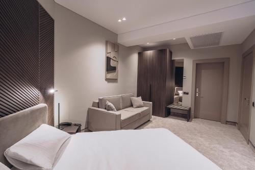 ein Schlafzimmer mit einem weißen Bett und einem Sofa in der Unterkunft Park Hotel Bristol in Uschhorod