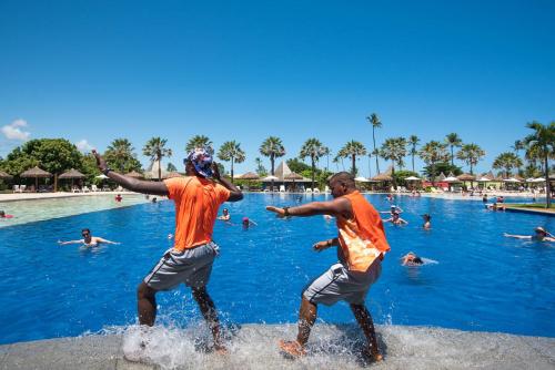 two men playing in the water at a swimming pool at Vila Galé Resort Marés - All Inclusive in Guarajuba