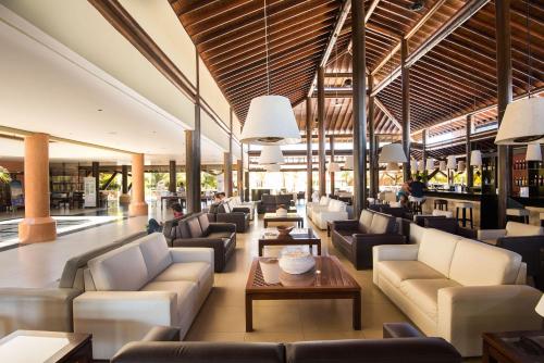 a lobby with couches and tables in a building at Vila Galé Resort Marés - All Inclusive in Guarajuba