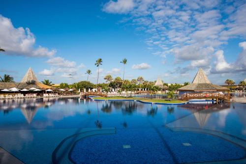 a large swimming pool at a resort with palm trees at Vila Galé Resort Marés - All Inclusive in Guarajuba