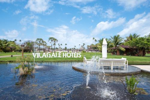 a fountain in the middle of a pond in a park at Vila Galé Resort Marés - All Inclusive in Guarajuba