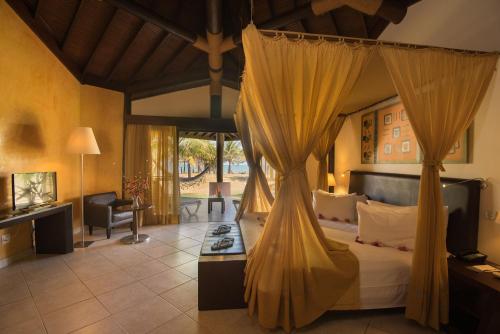 a bedroom with a bed with a canopy at Vila Galé Resort Marés - All Inclusive in Guarajuba