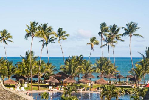 a view of a resort with palm trees and a pool at Vila Galé Resort Marés - All Inclusive in Guarajuba