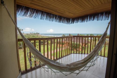 a hammock on a balcony with a view of the ocean at Vila Galé Resort Marés - All Inclusive in Guarajuba
