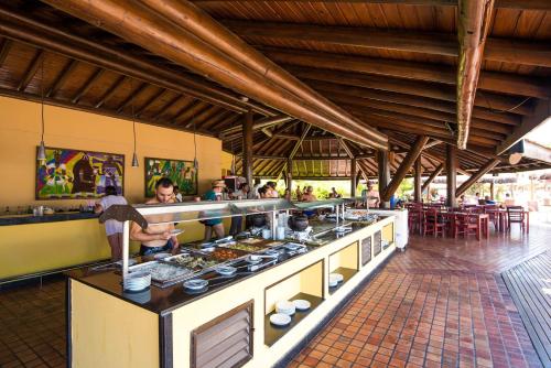 a kitchen with people preparing food in a restaurant at Vila Galé Resort Marés - All Inclusive in Guarajuba