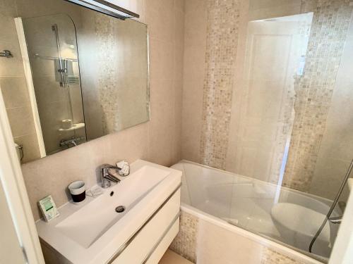 une salle de bain blanche avec un lavabo et une douche dans l'établissement Appartements Medicis, à Cannes