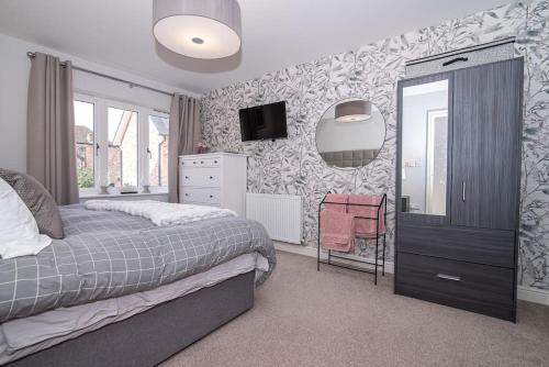 ラドローにあるElegant Ludlow Haven: 4Bed Ultimate Tranquilityのベッドルーム1室(ベッド1台、壁にテレビ付)