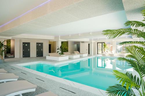 a swimming pool in a house with chairs and trees at Phoenix Relax Park in Bukovel