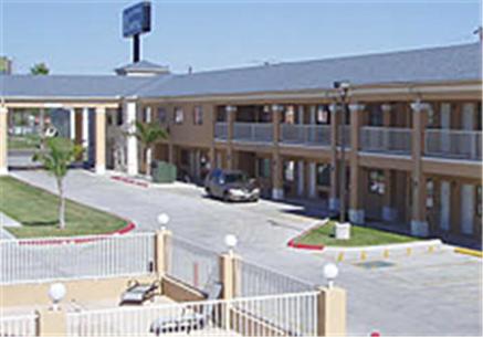 un grand bâtiment avec une voiture garée dans un parking dans l'établissement Texas Inn & Suites, à La Joya