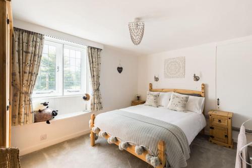 a bedroom with a large bed and a window at *COTSWOLDS CORNER COTTAGE* Nr Stow-on-the-Wold in Lower Swell