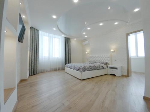 キーウにあるYulia apartment metro Osokorkiの白いベッドルーム(ベッド1台、大きな窓付)
