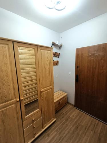 a room with wooden cabinets and a closet with a door at Apartament Oravski in Suchá Hora