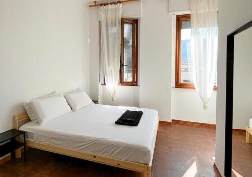 1 dormitorio con 1 cama con sábanas blancas y ventanas en Appartamento Terragni 1937, en Como