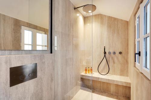 une salle de bain avec une douche avec une porte vitrée dans l'établissement TheLander - Serviced Apartment in Saint-Germain-des-Prés, à Paris