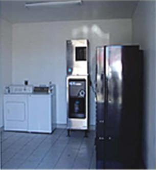 a kitchen with a stainless steel refrigerator in a room at Texas Inn & Suites in La Joya