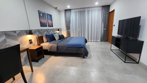 a bedroom with a bed and a flat screen tv at KhaoTao Homestay เขาเต่าโฮมสเตย์ in Khao Tao