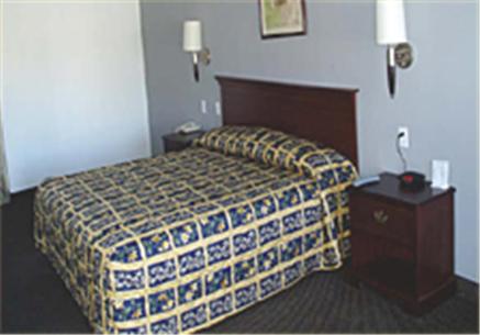 Habitación de hotel con cama y mesita de noche en Texas Inn & Suites en La Joya