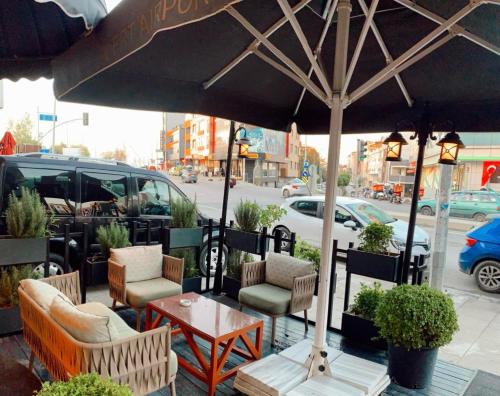 a patio with chairs and a table and an umbrella at FRT AİRPORT OTEL in Arnavutköy