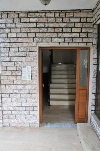 a brick wall with a wooden door and stairs at Seaside Studios in Paralia Dionysiou