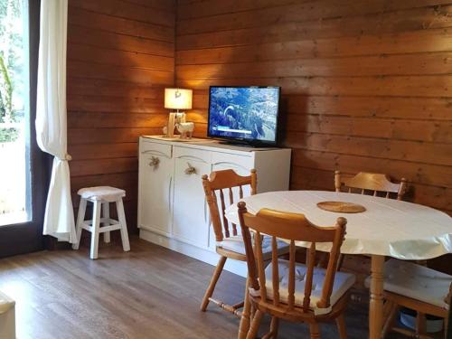 une salle à manger avec une table et une télévision dans l'établissement Appartement cosy 5 pers. à 300m des remontées, avec balcon et garage, à Châtel - FR-1-676-64, à Châtel