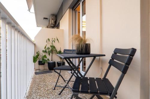 mały balkon z czarnym stołem i krzesłami w obiekcie Madan Apartment - Chania city center w Chanii