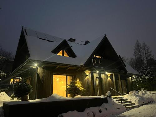 a house with a solar panel on the roof in the snow at Chalet V11 by Villa 11 Folk & Design in Zakopane