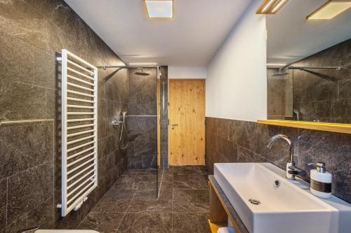 a bathroom with a sink and a shower at App Hubertus - Speikboden in Sand in Taufers