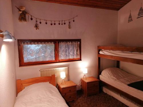 een slaapkamer met 2 bedden en een raam met verlichting bij Appartement Le Grand-Bornand, 3 pièces, 8 personnes - FR-1-241-250 in Le Grand-Bornand