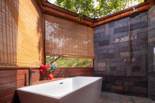 ein Bad mit einer großen Badewanne und einem Fenster in der Unterkunft Glamping Corazón del Molino in Ubaque