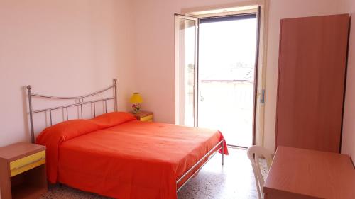 a bedroom with a bed and a large window at SanMarco Holiday Home in Ascea