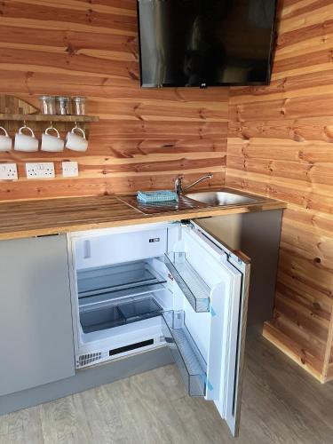an open refrigerator in a kitchen with a sink at Lakeside Fishing Retreats in Boston