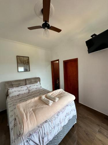 a bedroom with a bed with a ceiling fan at Suítes 4 Estações in São Thomé das Letras