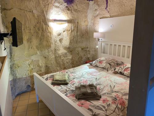 sypialnia z łóżkiem w kamiennej ścianie w obiekcie Gîte de charme 8 personnes centre Azay le Rideau w mieście Azay-le-Rideau