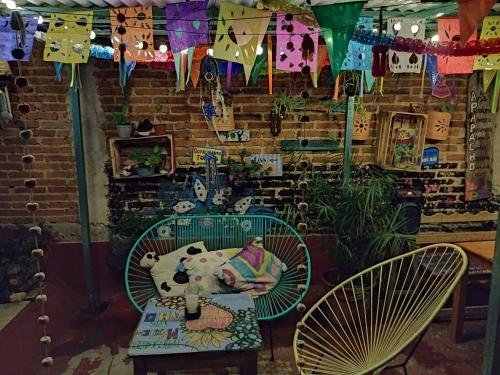 a room with two chairs and a table and flags at Casa Apapacho hostel in San Cristóbal de Las Casas