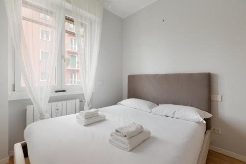 a bedroom with a white bed with towels on it at GuestHost - Cimiano M2 Balcony Apartment in Milan