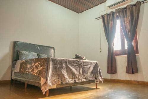 Un dormitorio con una cama con una manta. en Hermosa casa de 3 dormitorios en Encarnación