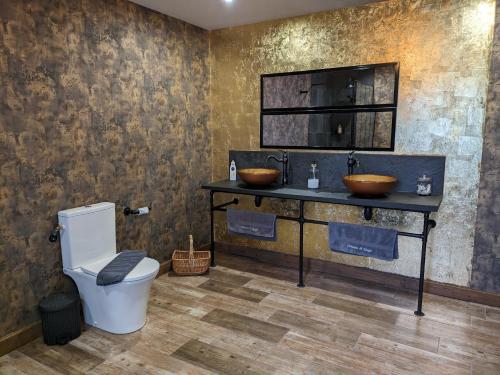 ein Badezimmer mit zwei Waschbecken und einem WC in der Unterkunft Château de Saugé in Saivres