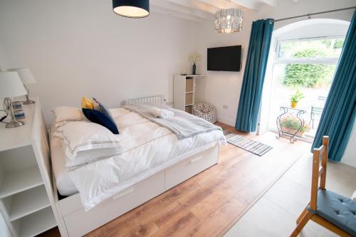 a bedroom with a white bed with blue curtains at Kilpatrick Glebe in Crossabeg