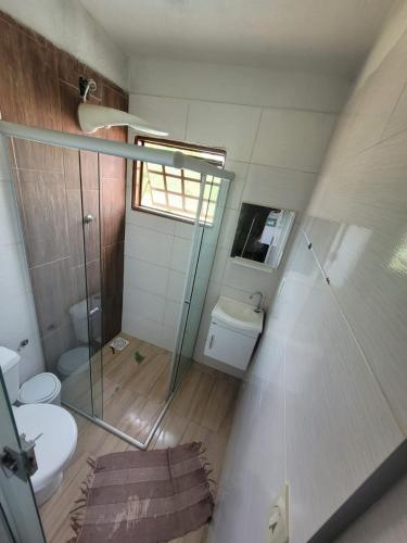 a bathroom with a glass shower and a toilet at Casa ponta do sol in Capitólio