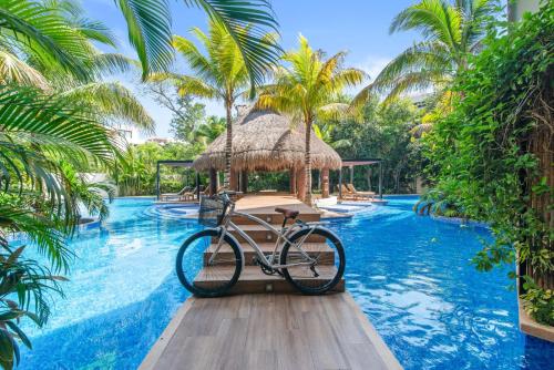 una bicicleta estacionada en una piscina en un complejo en Luxurious Penthouse with Jungle View & Private Pool en Tulum