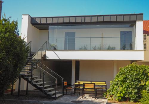 a house with a staircase and a table and chairs at Apartament przy Małej Panwi "I" in Opole