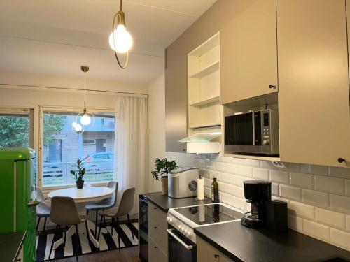 a kitchen with a table and a dining room at Viihtyisä kaksio Annalassa, Free parking & Sauna in Tampere